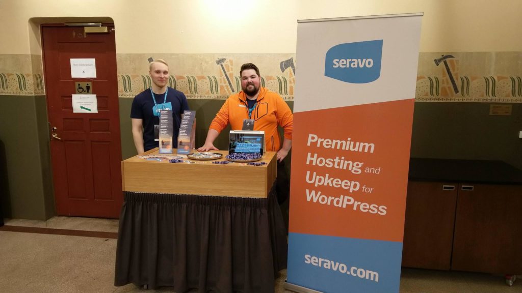 A picture of Seravo's sponsor booth with two people.